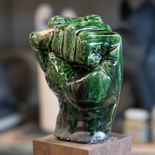 hand van keramiek met groen geglazuurd